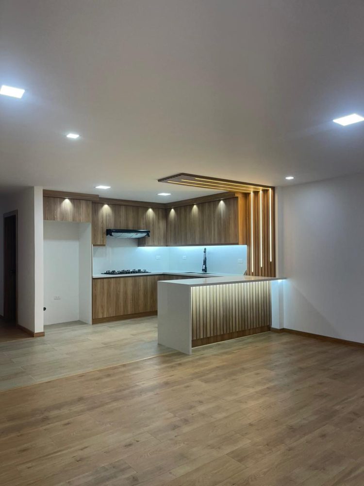 Sala y cocina terminadas con madera e iluminación LED